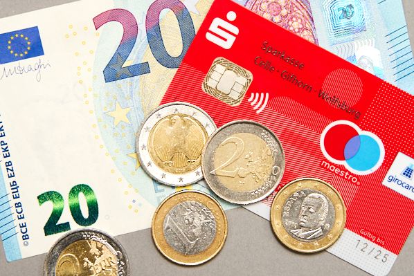 Geld und Bankkarte mit Münzen: Bewerbungsfotos Kosten
